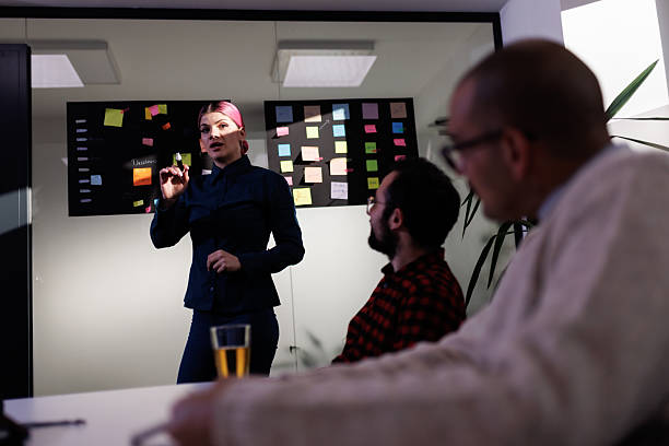 istock Business meeting focused on strategy development and team collaboration in a modern office space with colorful notes displayed on the wall 2238424376