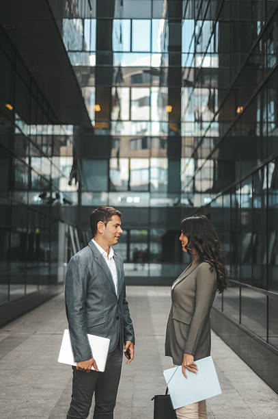 istock Business professionals talking outside modern office building 2238428712