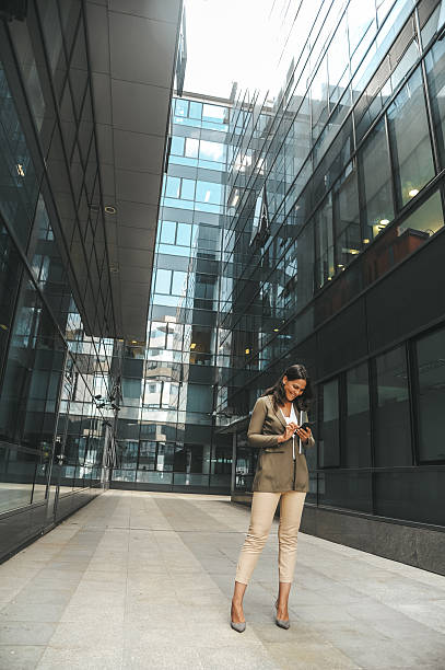 istock Professional Woman Using Smartphone Outside Office Building 2238428768