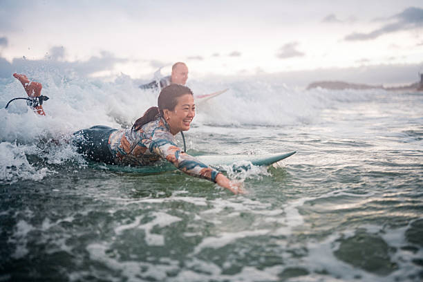 istock Joyful Diverse Surfing Couple Riding Waves at Gold Coast 2238429488