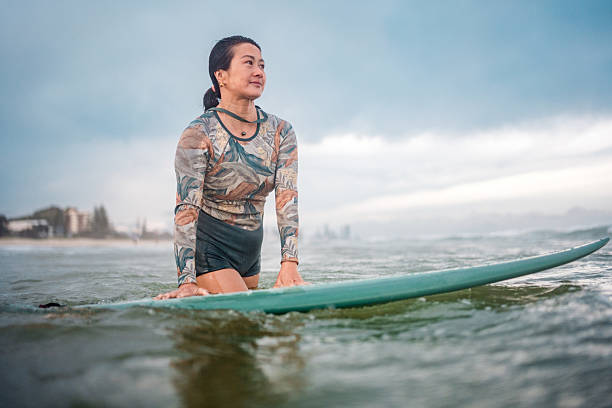 istock Confident Asian Female Surfer on a Wave at Gold Coast Beach 2238429497