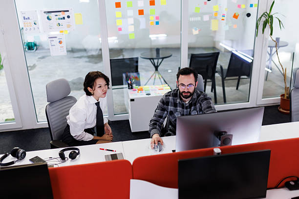 Businesspeople collaborating in a modern office setting while discussing project details during daytime