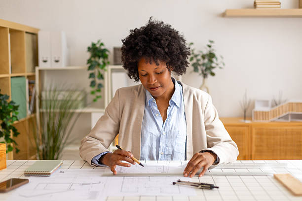 istock Black woman architect working on building blueprint design 2238436440