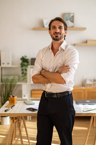 istock Confident businessman standing with arms crossed in modern office 2238436490