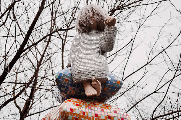 Kyiv, Ukraine - January 04, 2014 - Sculpture of child with mosaic design surrounded by bare trees.
