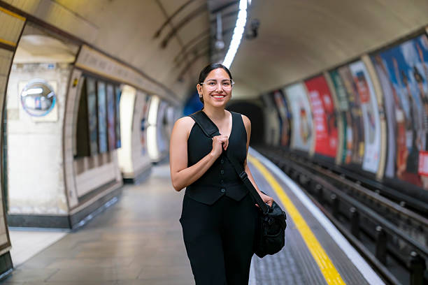 istock Young Latina woman smiling while using phone inside London Underground station, England during daily commute with confidence and style 2238448584
