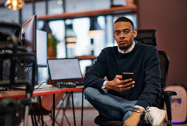 istock After Hours Reflection: African American Man Using Smartphone in Office. 2238448715