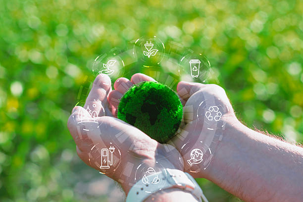 istock A pair of hands with a small green, textured globe representing the Earth, surrounded by a circular overlay of white, glowing icons symbolizing sustainability, recycling, and clean energy. 2238449432