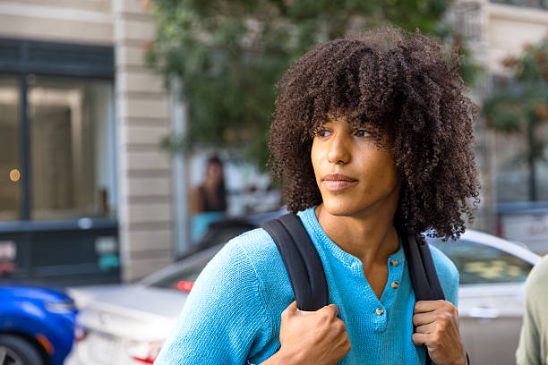 istock Young Curly Haired Multiracial Man with a Backpack in Brooklyn, New York City 2238451103