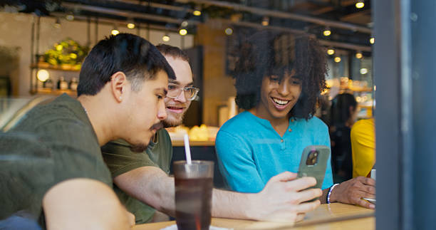 istock White Man Showing Smartphone to Friends inside DUMBO, Brooklyn Cafe 2238451215