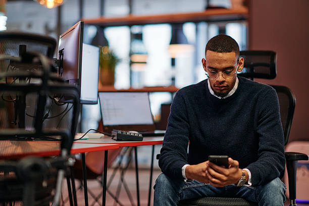 istock After Hours Reflection: African American Man Using Smartphone in Office. 2238451425