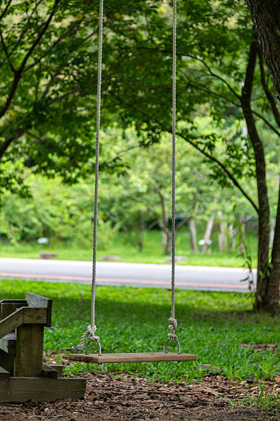 A wooden swing in an outdoor space is a simple yet beautiful leisure activity to enjoy in a park or woodland.