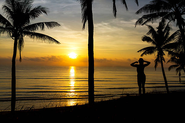 istock Sunrise with silhouette woman and coconut 2238452461
