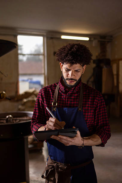 istock Barista in Apron Writing on Tablet in Industrial Coffee Shop Setting 2238455809