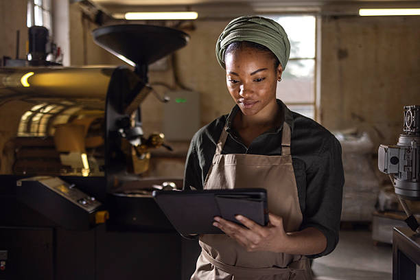 Professional Barista Using Tablet in Artisan Coffee Roasting Facility