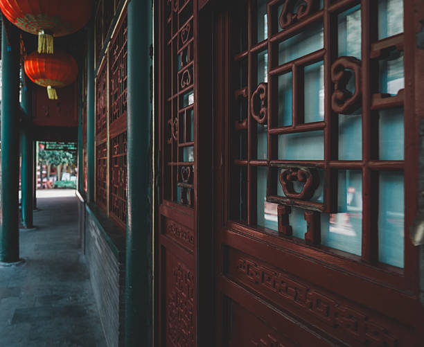 istock Intricate, ornate wooden latticework adorns a traditional Beijing structure, showcasing symmetrical patterns and a warm, aged wood texture against a subtly overcast sky. 2238456463