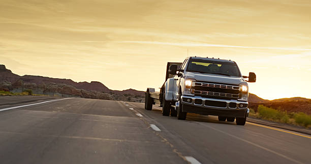 Vehicle mounted shot looking back at a truck driving on Interstate 70 in Emery County, Utah at sunset.