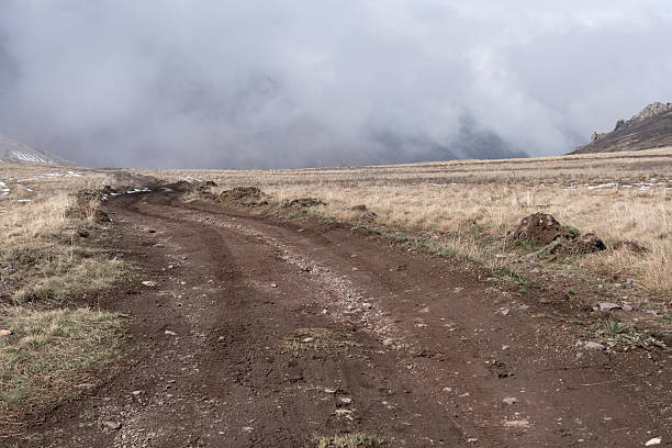 istock Winding mountain road disappearing into thick fog and mist 2238460759