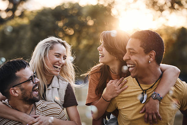 istock Happy couples having fun while piggybacking in the park at sunset. 2238466128