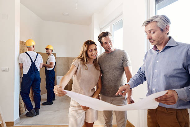 istock Happy couple working on plans with an architect during home renovation process. 2238468168