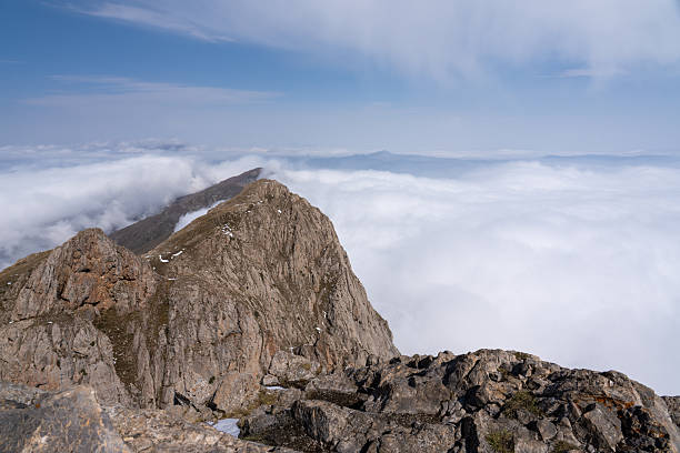 istock Snow-dusted alpine mountain range shrouded in fog and clouds 2238470290