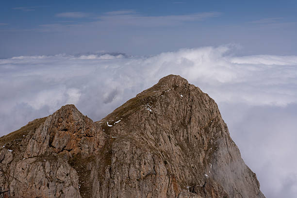 istock Snow-dusted alpine mountain range shrouded in fog and clouds 2238470515