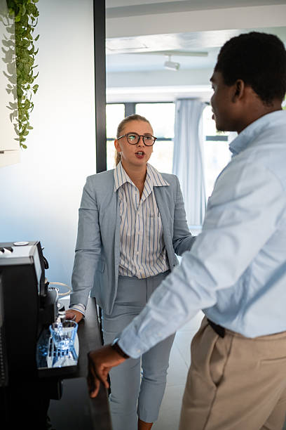 istock Business colleagues having serious discussion near office coffee machine 2238471667