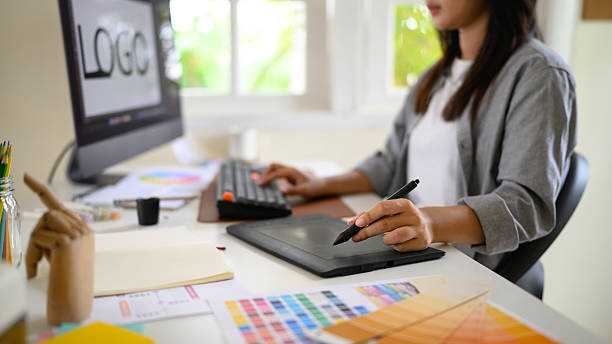 istock Female graphic designer working at a modern desk using a digital drawing tablet and computer 2238472236