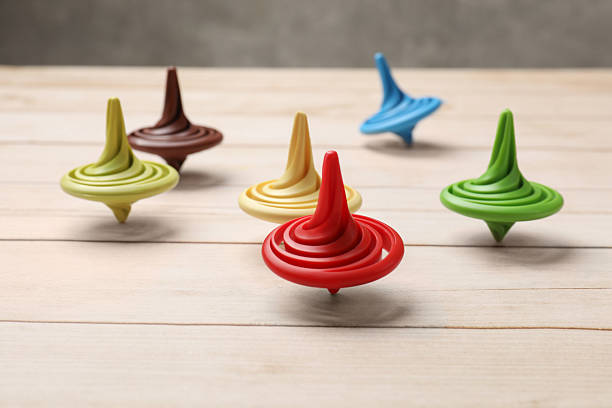 Vintage toy top spinning on wood surface