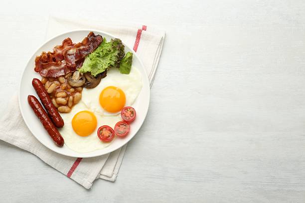 istock Delicious breakfast with sunny side up eggs on white table, top view. Space for text 2238477564