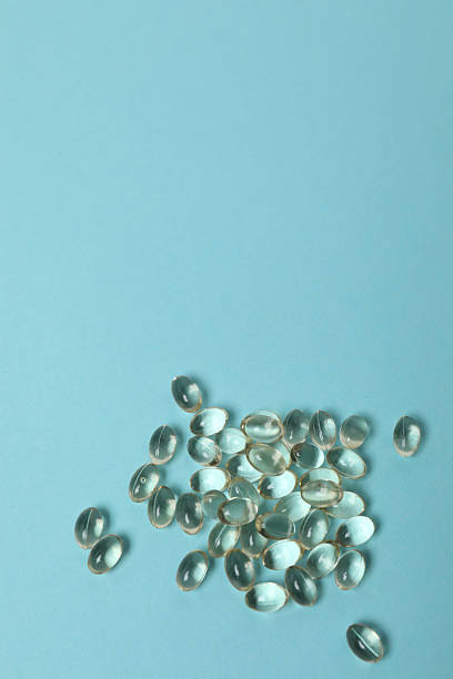 istock Vitamin pills and bottle on blue background, top view. Space for text 2238478486