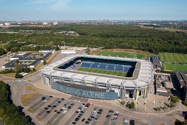 Brondbyvester, Denmark – August 10, 2021: Drone shot of Brondby Stadium with Copenhagen skyline in distance.