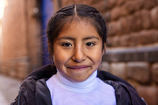 Peruvian little girl posing in Cuzco. \nThe Sacred Valley of the Incas or Urubamba Valley is a valley in the Andes  of Peru, close to the Inca capital of Cusco and below the ancient sacred city of Machu Picchu.