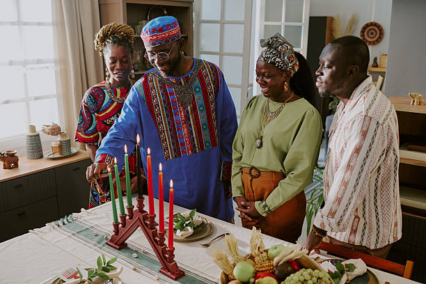 istock Middle Aged Black Man Lighting Kinara Surrounded by Smiling Black Adults 2238484842