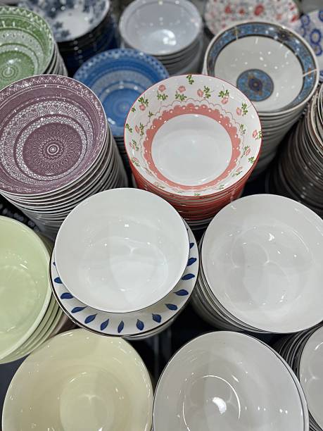 istock Top view of assorted ceramic bowls and plates with decorative patterns, neatly stacked in a store display. 2238485100