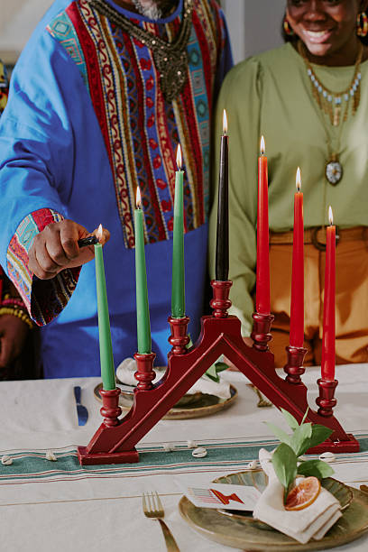 istock Middle Aged Black Man Lighting Kinara Candles during Kwanzaa Celebration 2238486341