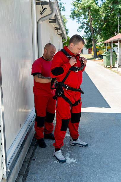 istock Experienced instructor assists student with tandem skydiving harness and gear for a safe jump 2238486344