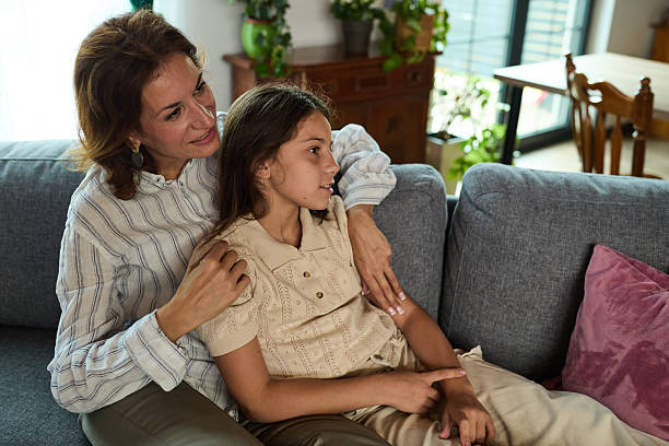 istock Mother and daughter sitting on a sofa in a cozy home environment 2238486461