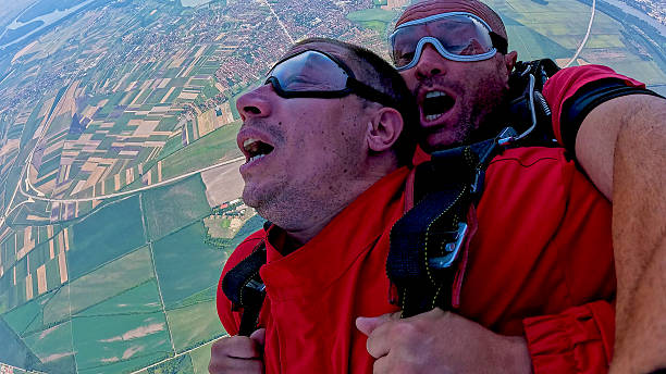 istock Tandem skydiving selfie during freefall with dramatic aerial view and exhilarated expressions 2238486564