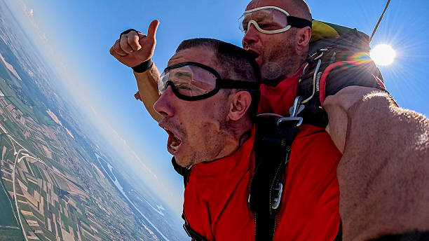 istock Tandem skydivers in freefall selfie with wrist cam, adrenaline, and expansive landscape below 2238486621