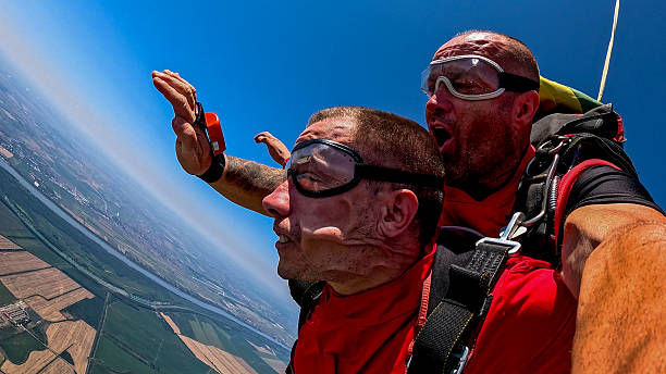 istock Tandem skydivers selfie during freefall with wrist camera and dramatic landscape below 2238486692