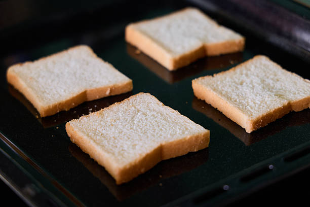Freshly sliced white bread on a grill, perfectly set up and ready for toasting or sandwich making delights