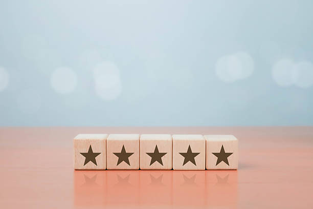 istock Five wooden blocks with star symbols on table, representing customer satisfaction, five star rating, quality service review, positive feedback, excellent business performance, trust, and reputation. 2238486749