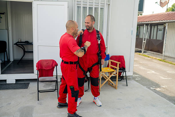 istock Two skydiving instructors prepare a student for a tandem jump with safety harness and gear 2238486845