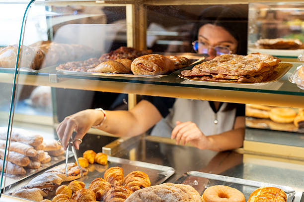istock Woman working in bakery selecting fresh pastries for sale 2238486861