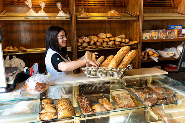istock Woman working in bakery arranging fresh bread 2238486871