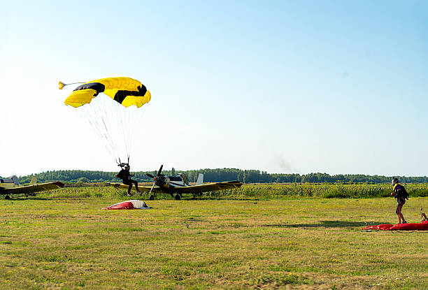 istock Skydive action on a bright day with a yellow canopy approaching the ground at a field landing 2238487041