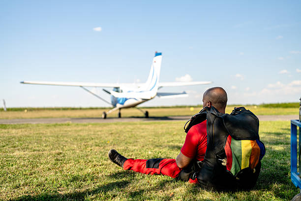 Skydivers Resting by the Runway Before Jump, Gear Ready and Team Focused on the Flight Schedule