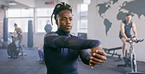 Athlete caucasian man doing warm up in the gym and stretch legs.Closeup.