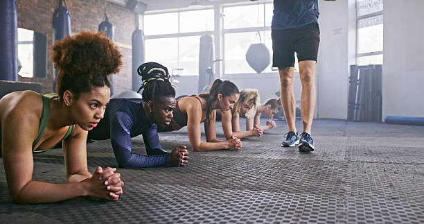 istock Group Fitness Session With Trainer Guiding Participants Performing Exercises 2238487413